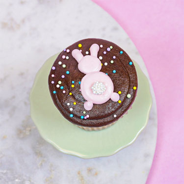 chocolate iced cupcake with pink bunny bum decoration