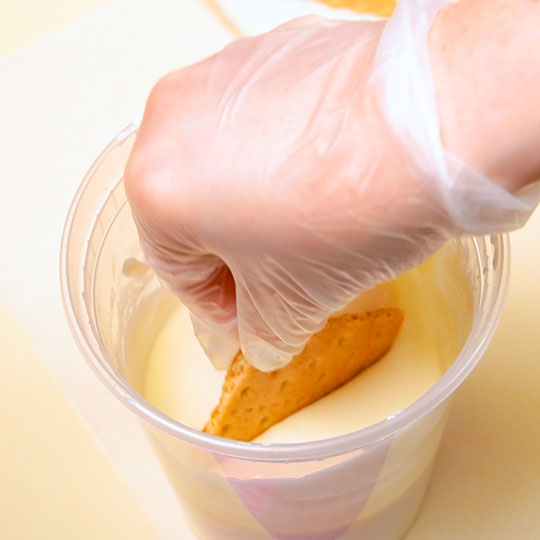 dipping graham cracker in melted white chocolate