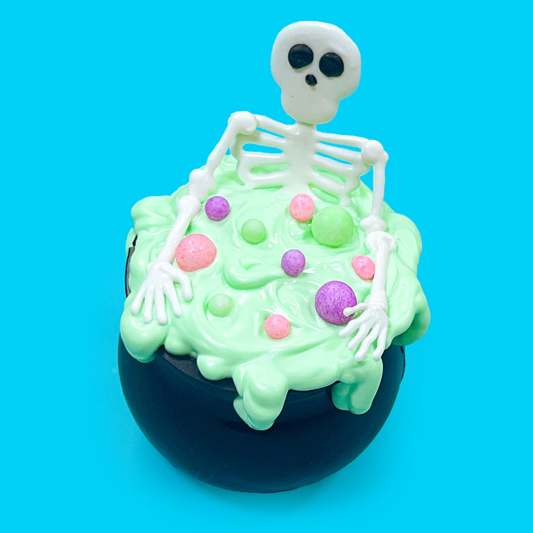 adding white chocolate skeleton head to halloween hot chocolate bomb