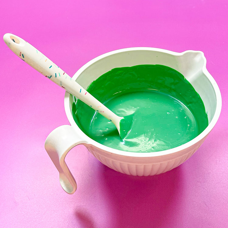 white bowl of melted green chocolate wafers