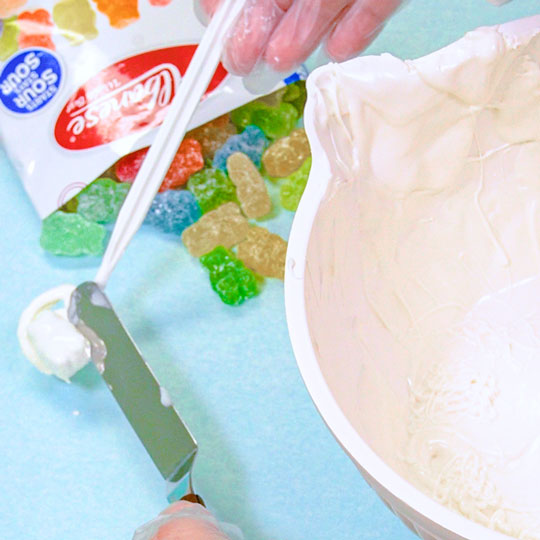 putting chocolate dipped gummy bear on parchment paper