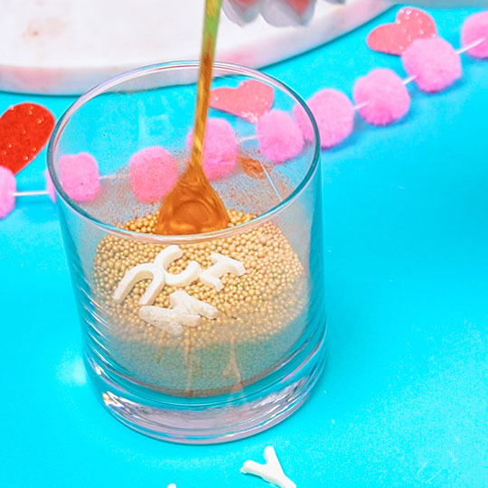 chocolate letters in cup of rose gold sprinkles