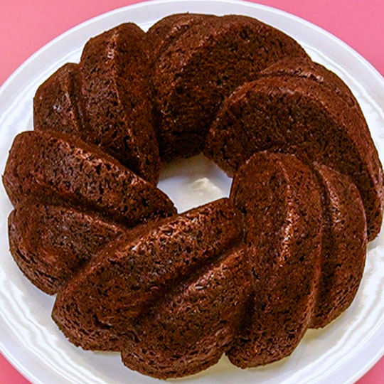 chocolate bundt cake on a white cake stand