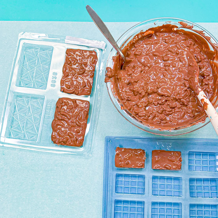 chocolate pretzel mixture added to bar shaped chocolate molds