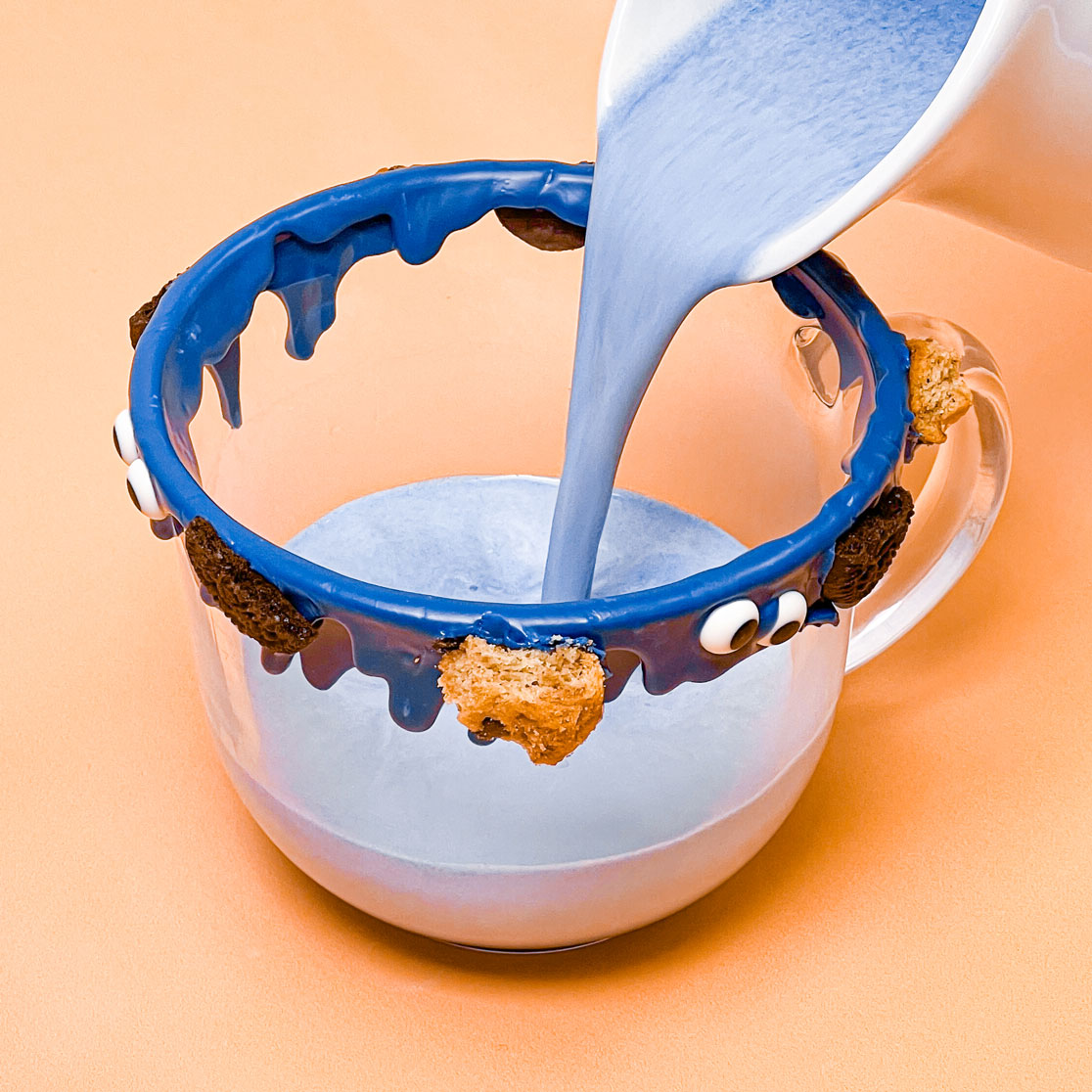 pouring blue hot chocolate into prepared mug