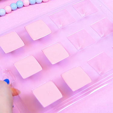 pyramid chocolate mold filled with melted pink chocolate