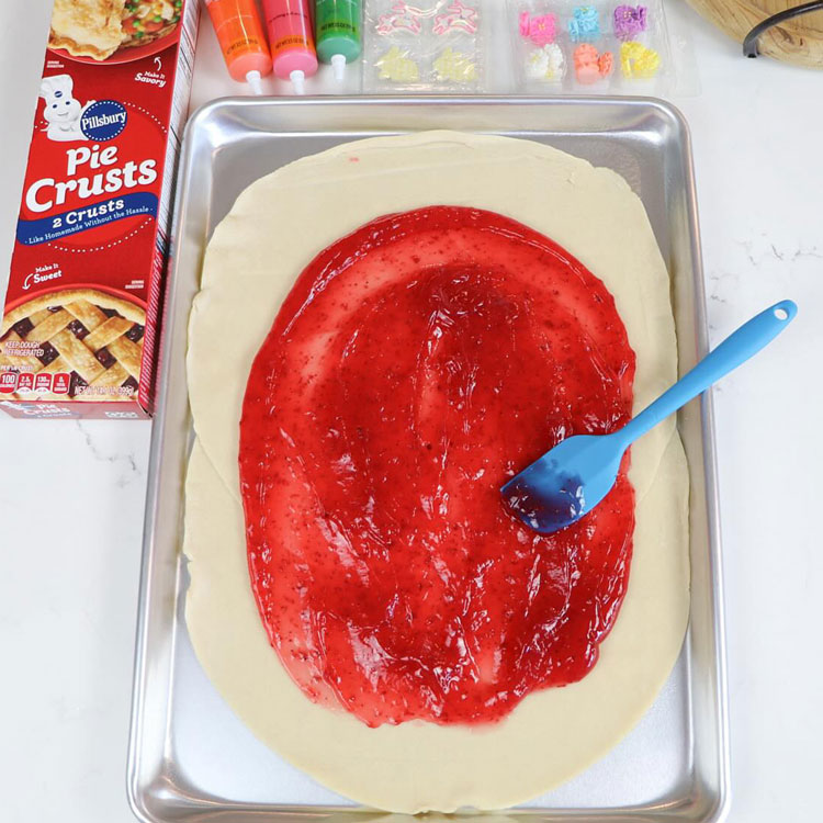 strawberry pastry filling spread onto pie dough