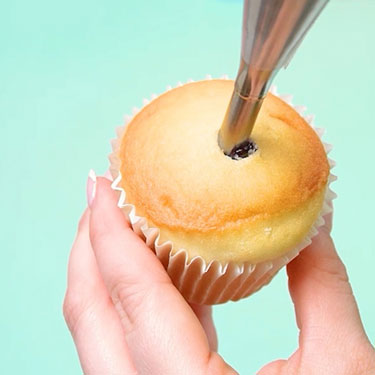 using a bismarck tip to fill a cupcake with blueberry filling