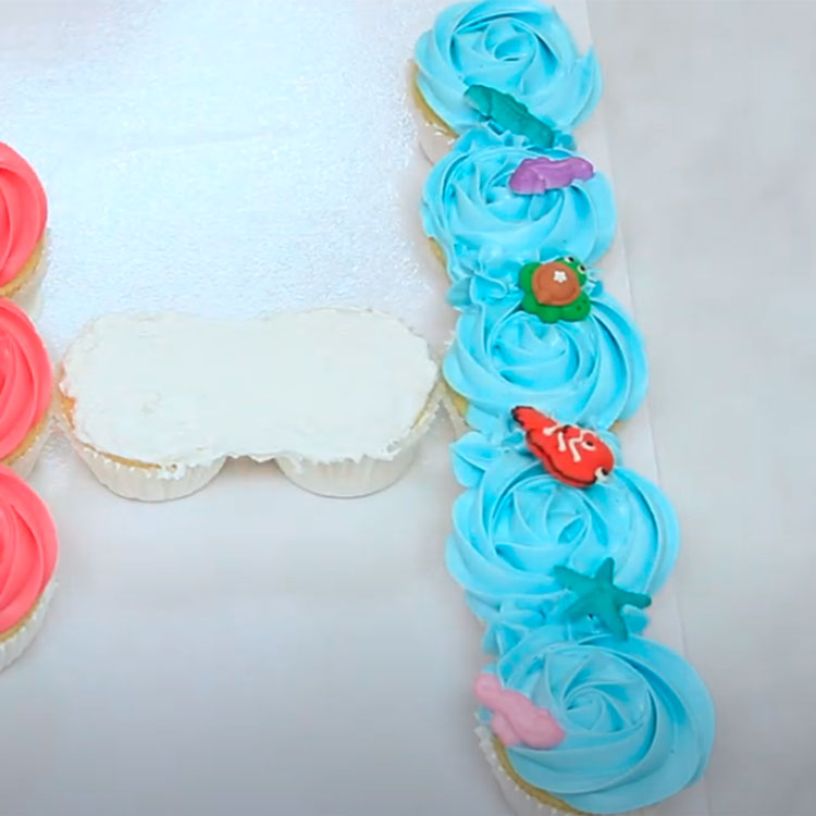 adding edible icing decorations shaped like sea creatures