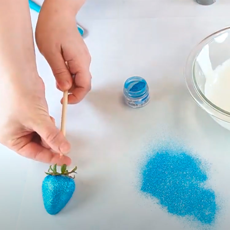 removing skewer from blue glitter strawberry