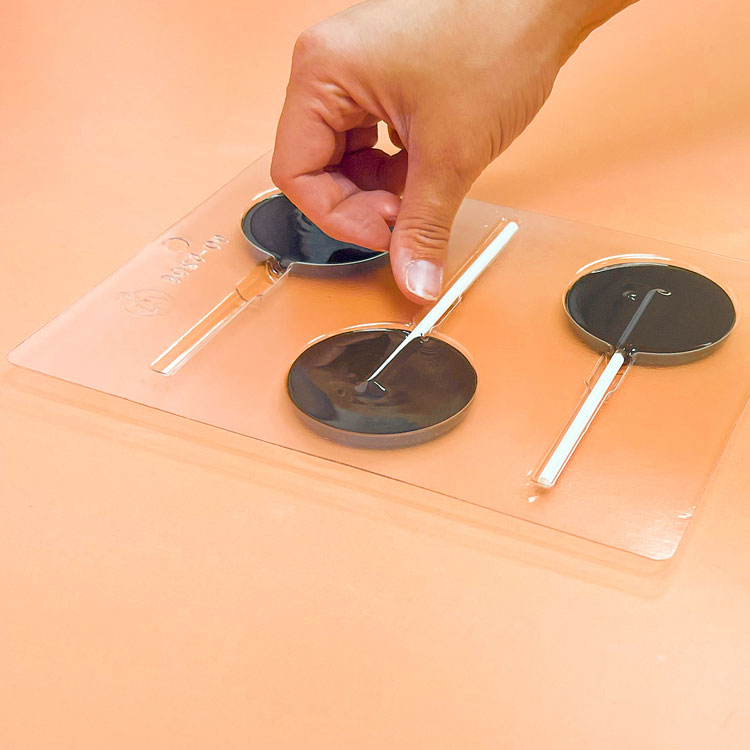 Adding sucker stick into chocolate mold