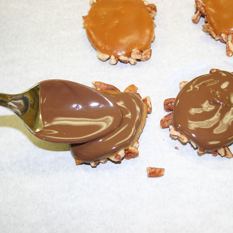 covered pecan and caramel mounds with melted chocolate