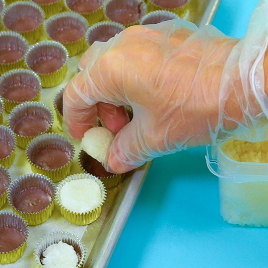 adding coconut dough into candy cup