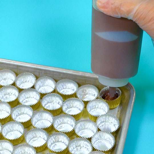 filling foil candy cups with melted dark chocolate