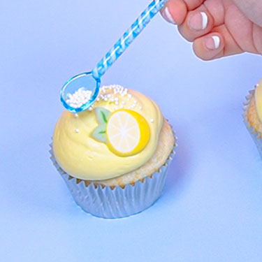 adding white sprinkles to cupcakes