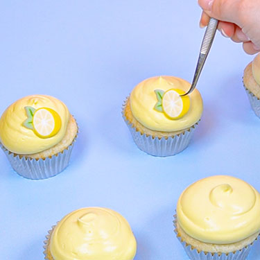 adding lemon sugar decorations to cupcakes