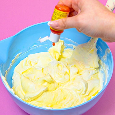adding yellow food coloring to lemon frosting