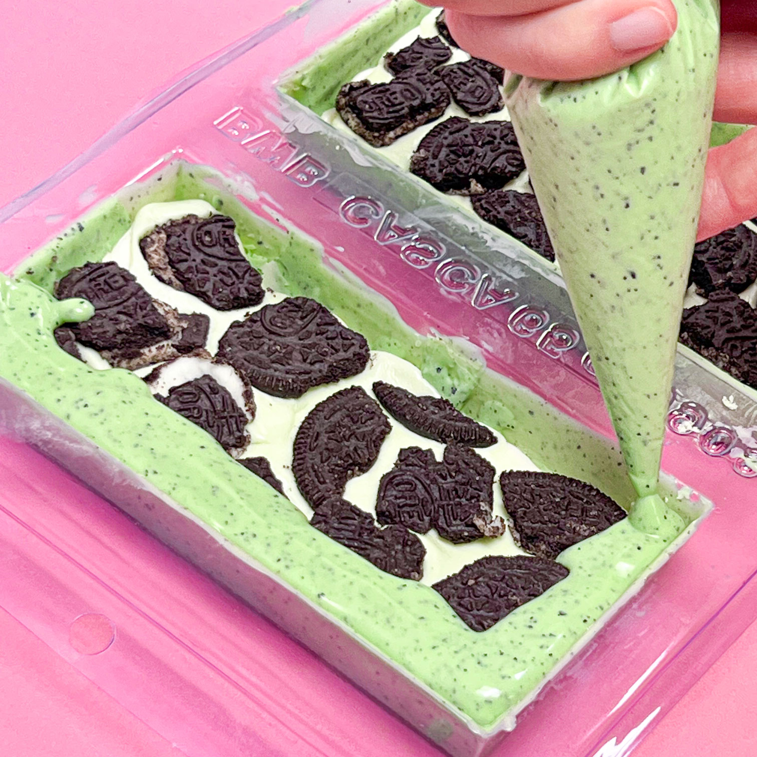 piping melted mint chocolate to cover candy filling