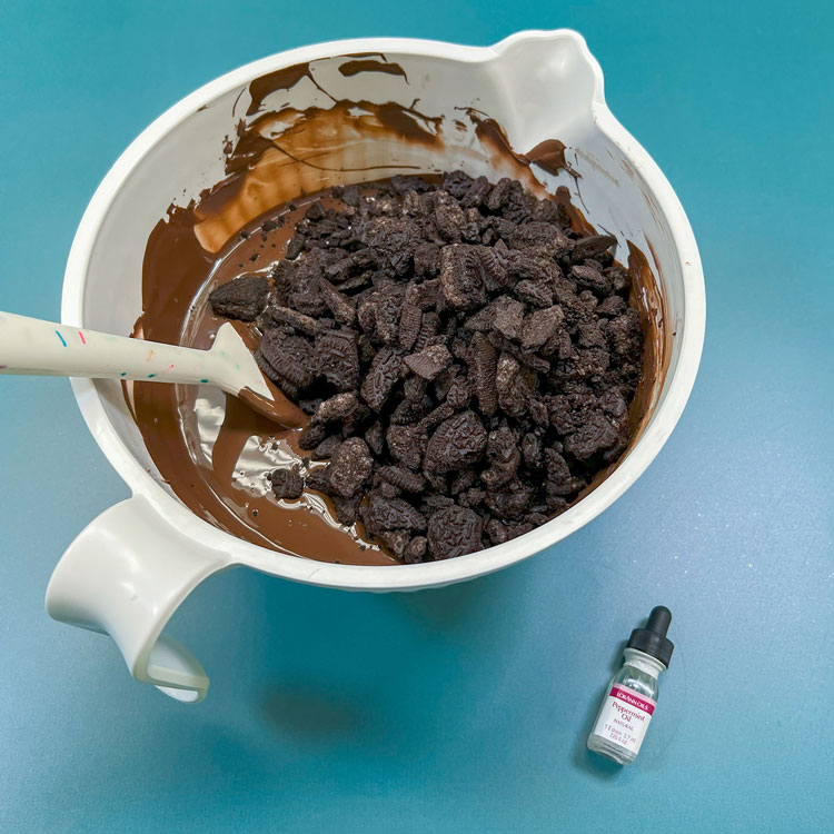 melted dark chocolate wafers and crushed oreos in bowl