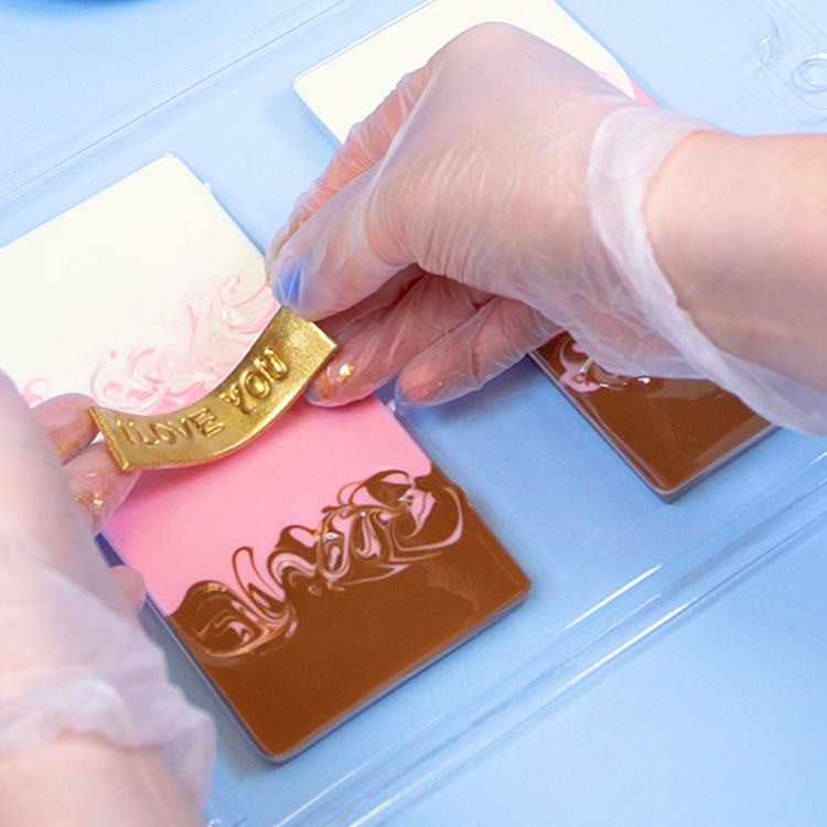 adding fondant words to back of chocolate bar