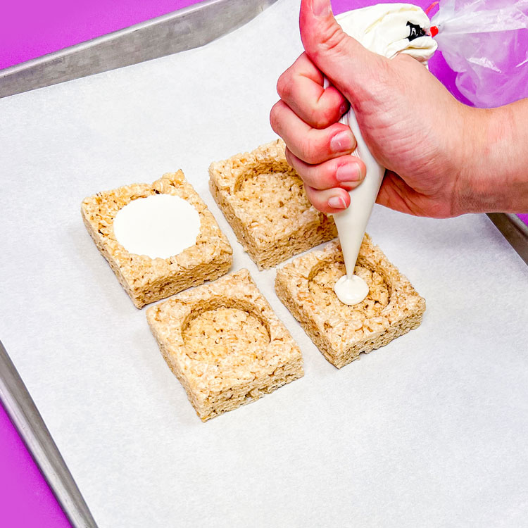 piping melted white chocolate onto rice krispie treat