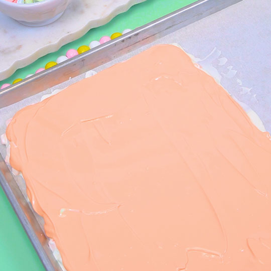 orange chocolate spread out into a thin layer on cookie sheet