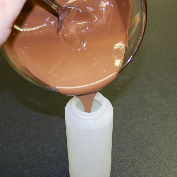 adding melted chocolate into a sueeze bottle for making peanut butter eggs