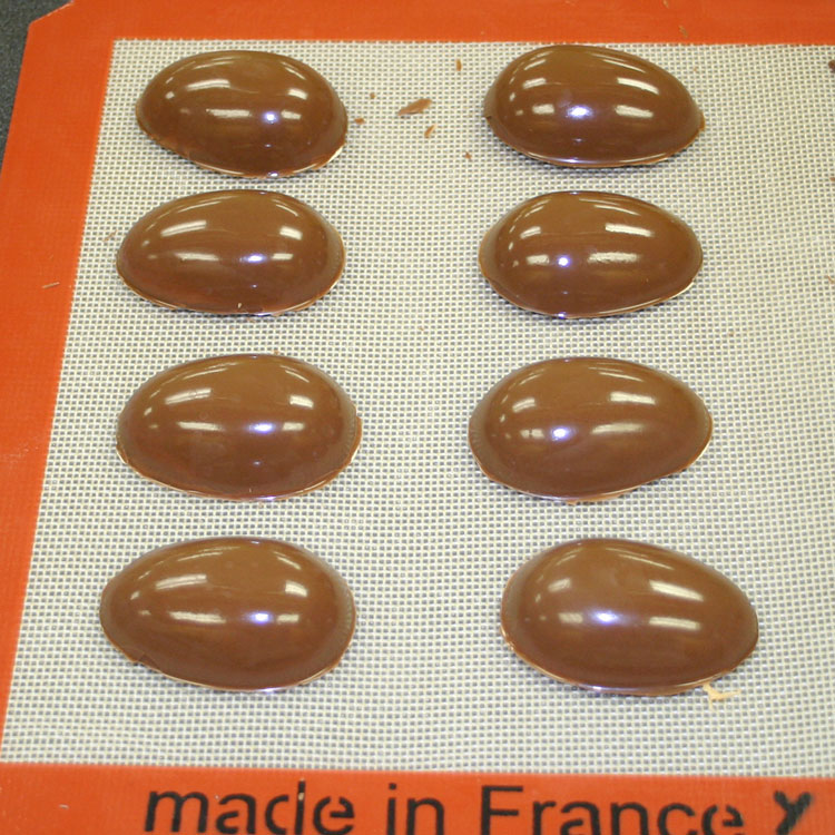 chocolate peanut butter eggs flipped onto a silicone mat