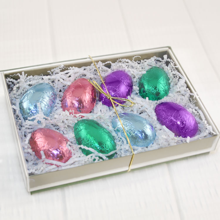 foil wrapped peanut butter eggs in a candy box.