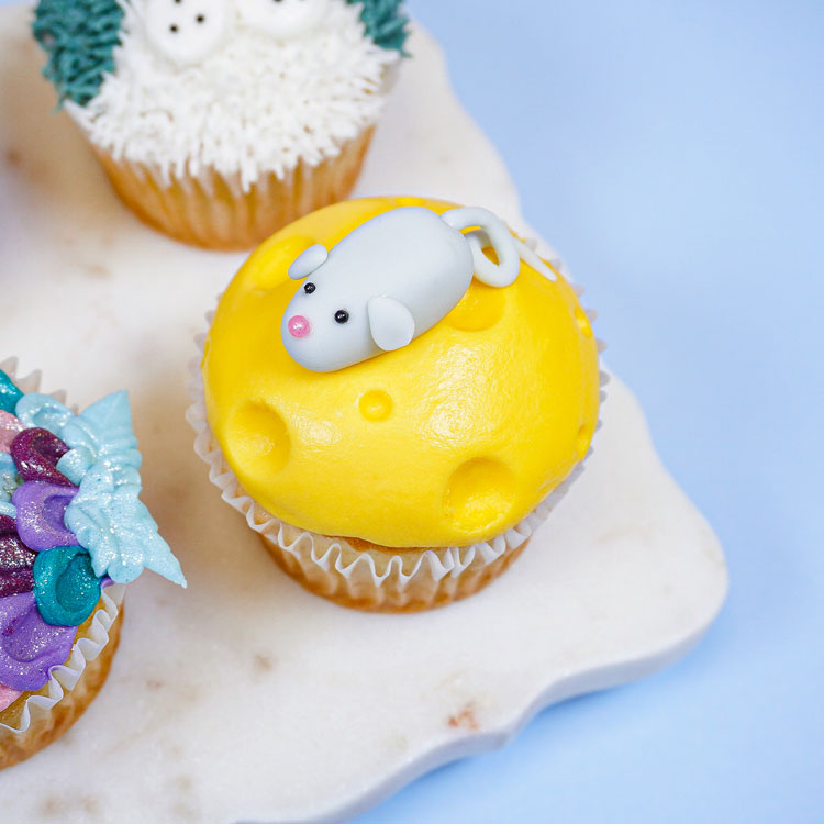 cupcake decorated to look like a mouse on cheese