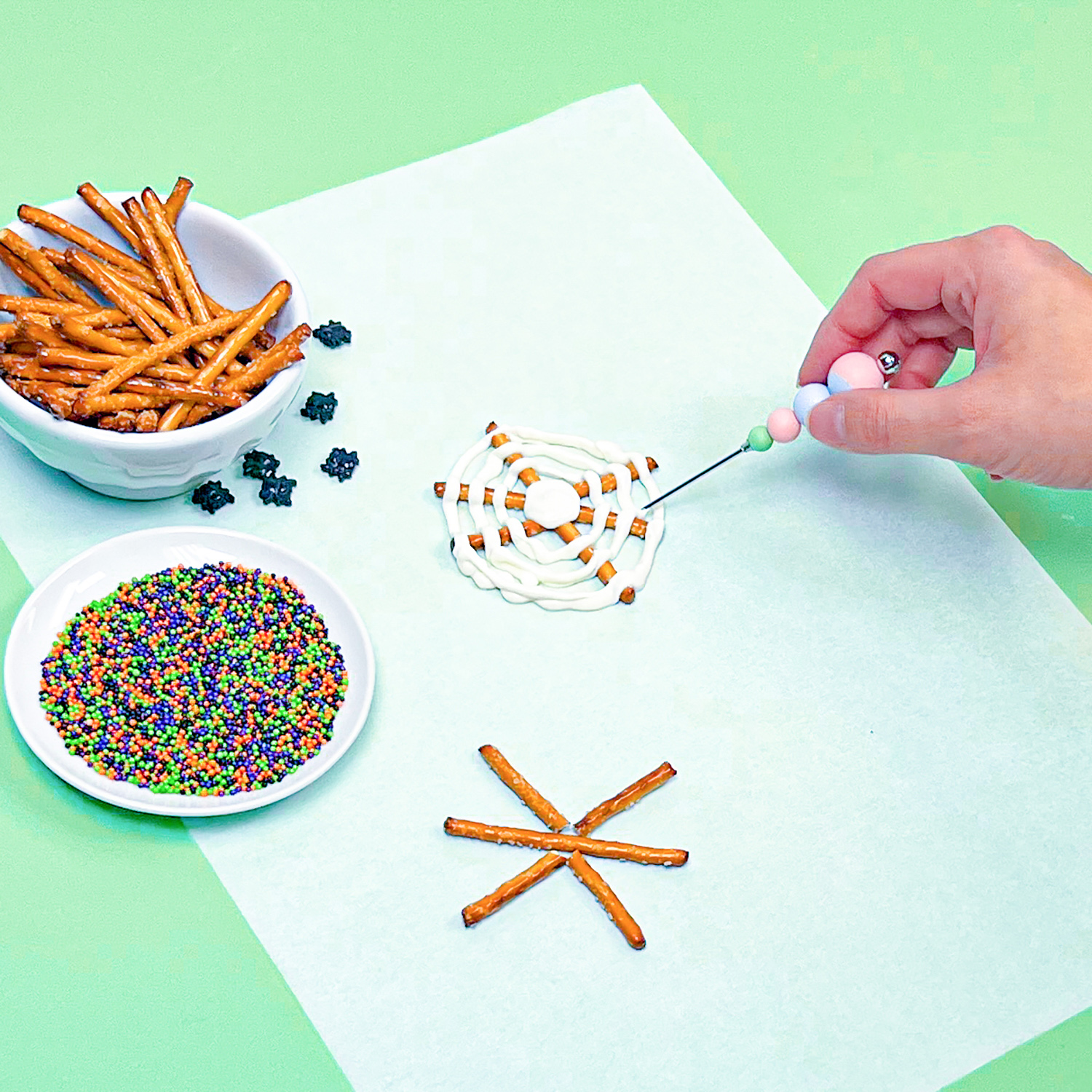 dragging toothpick through melted chocolate to create spider web