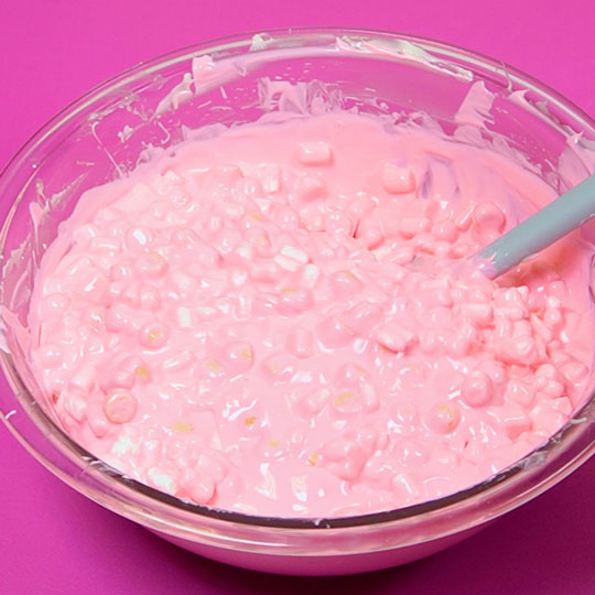 mixing marshmallows and cookie pieces into melted chocolate