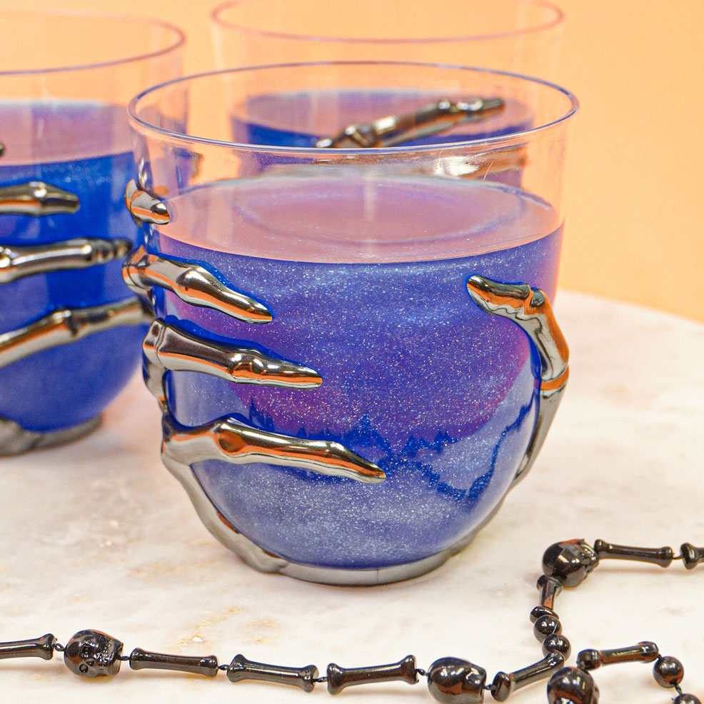 halloween shimmer drink in skull hand cup