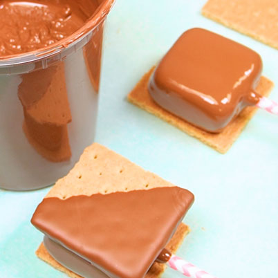 putting chocolate dipped marshmallow onto graham cracker