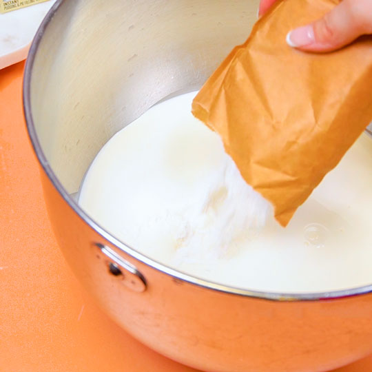 pouring white chocolate pudding mix into mixing bowl