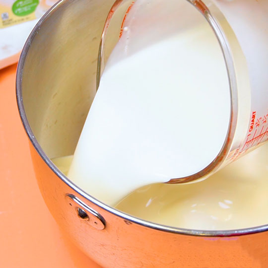 pouring whipping cream into mixing bowl