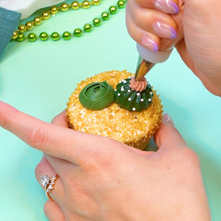 piping buttercream flower onto cactus