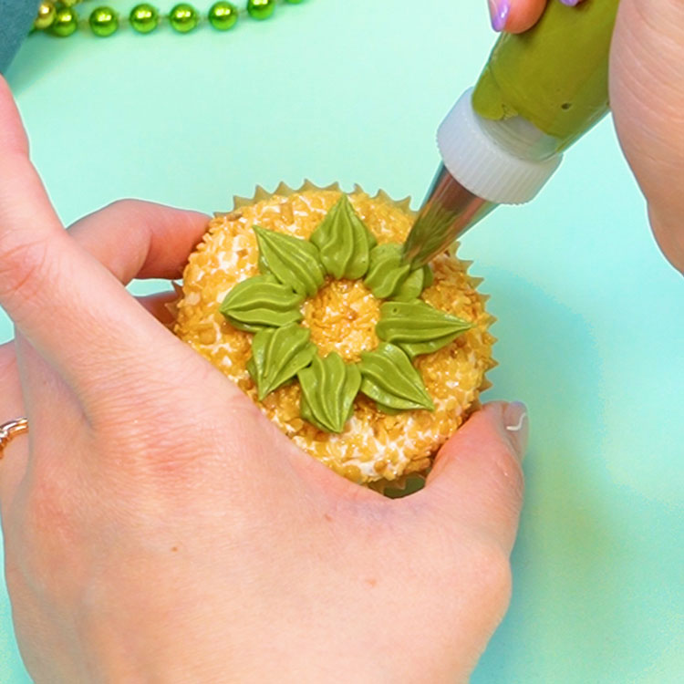 piping a succulent on a cupcake using a star tip