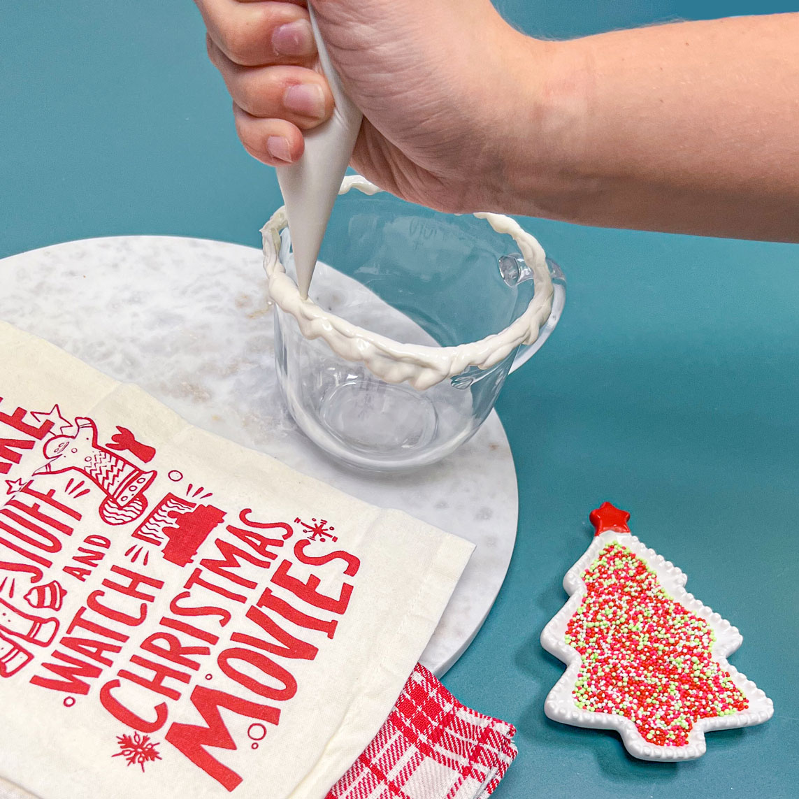 piping melted white chocolate onto rim of glass