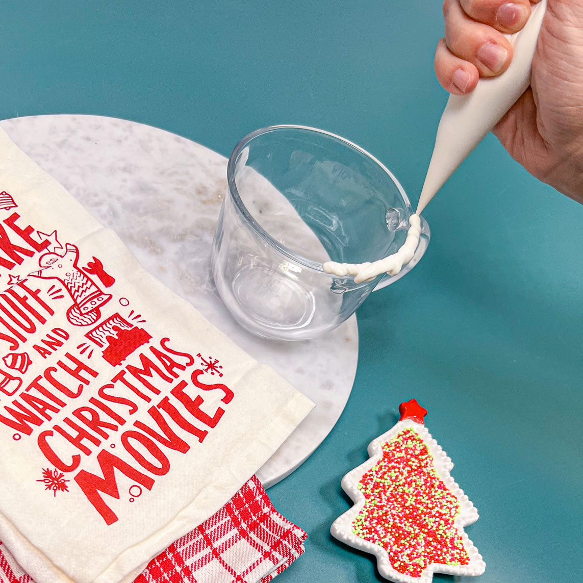 piping white chocolate onto rim of glass