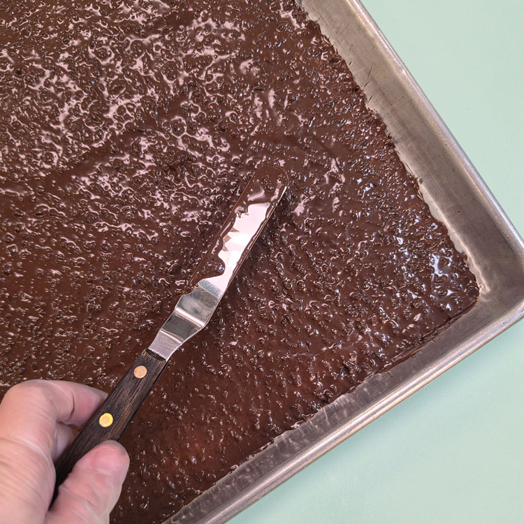 spreading mixture in a half sheet baking pan