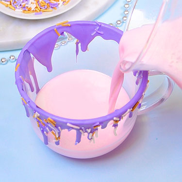 pouring pink hot chocolate into mug