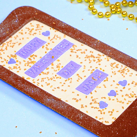 adding white edible glitter to back of chocolate bar